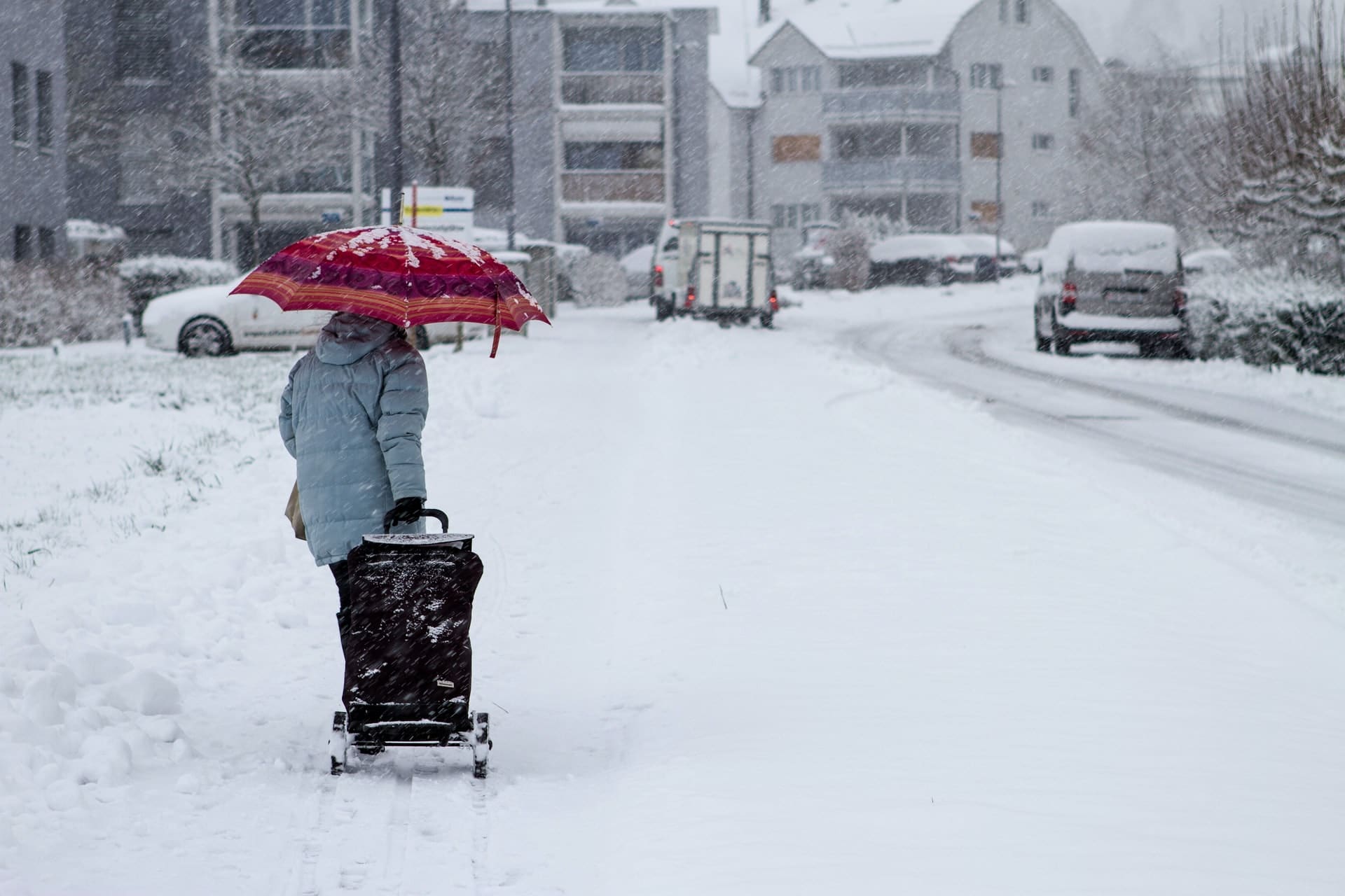 A woman walking with a cart in the snow representing new time limitations on slip and fall claims due to snow and ice