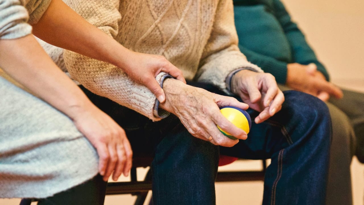 A female staffer helping a nursing home resident representing pay equity in Ontario