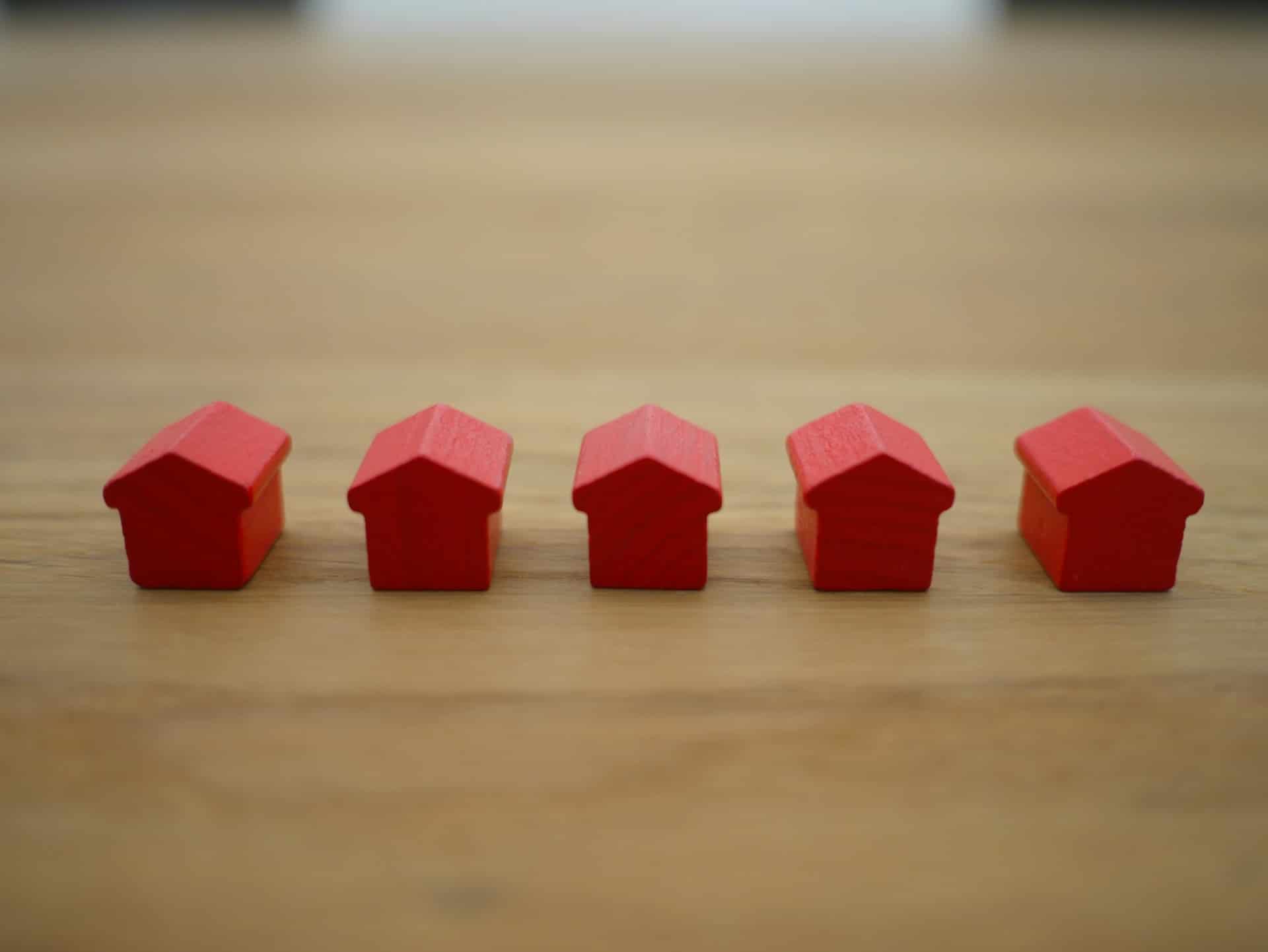 Small wooden toy houses representing unconditional offers on real estate