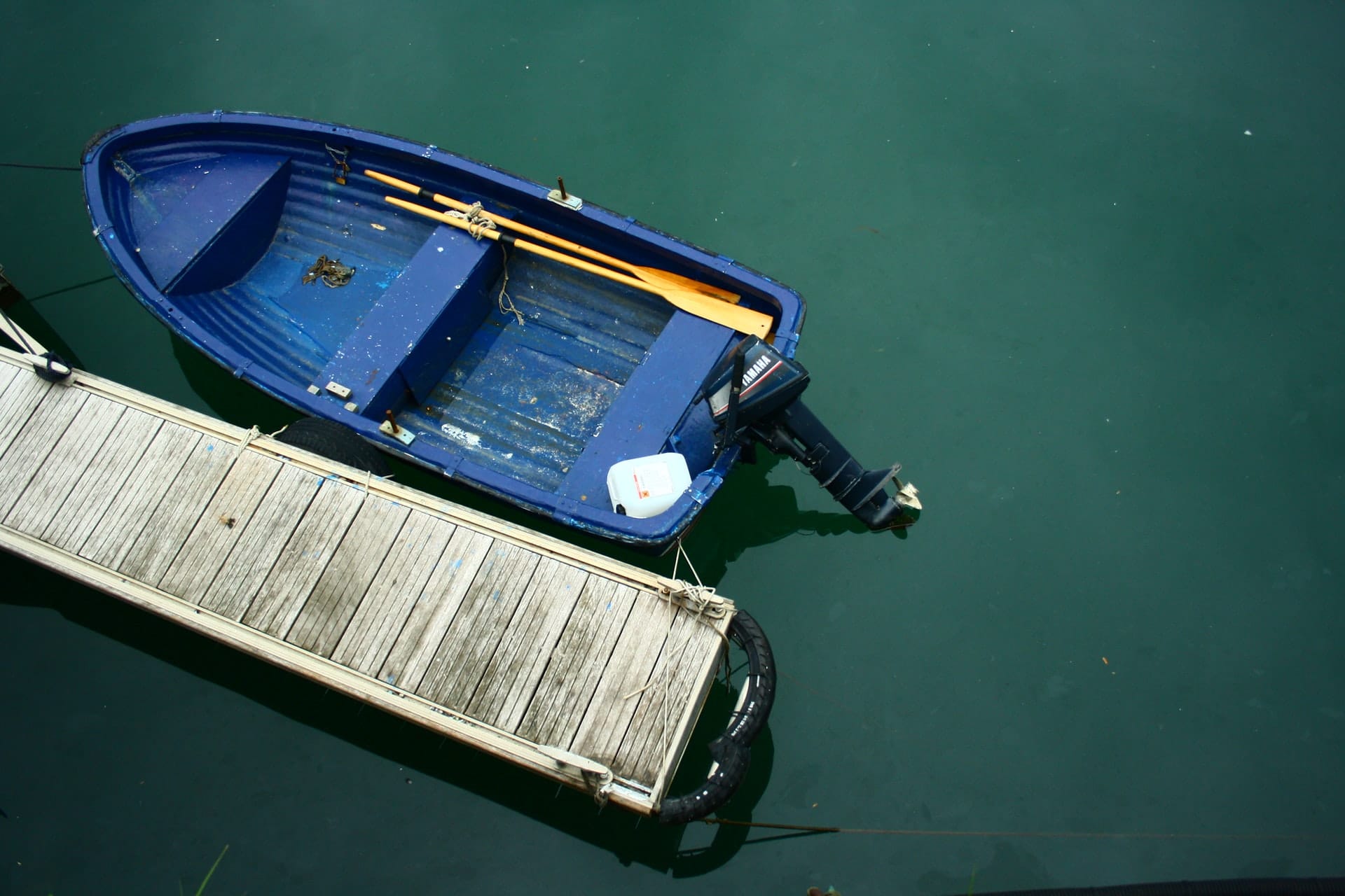 A small motorboat beside a dock representing boating safety in Ontario