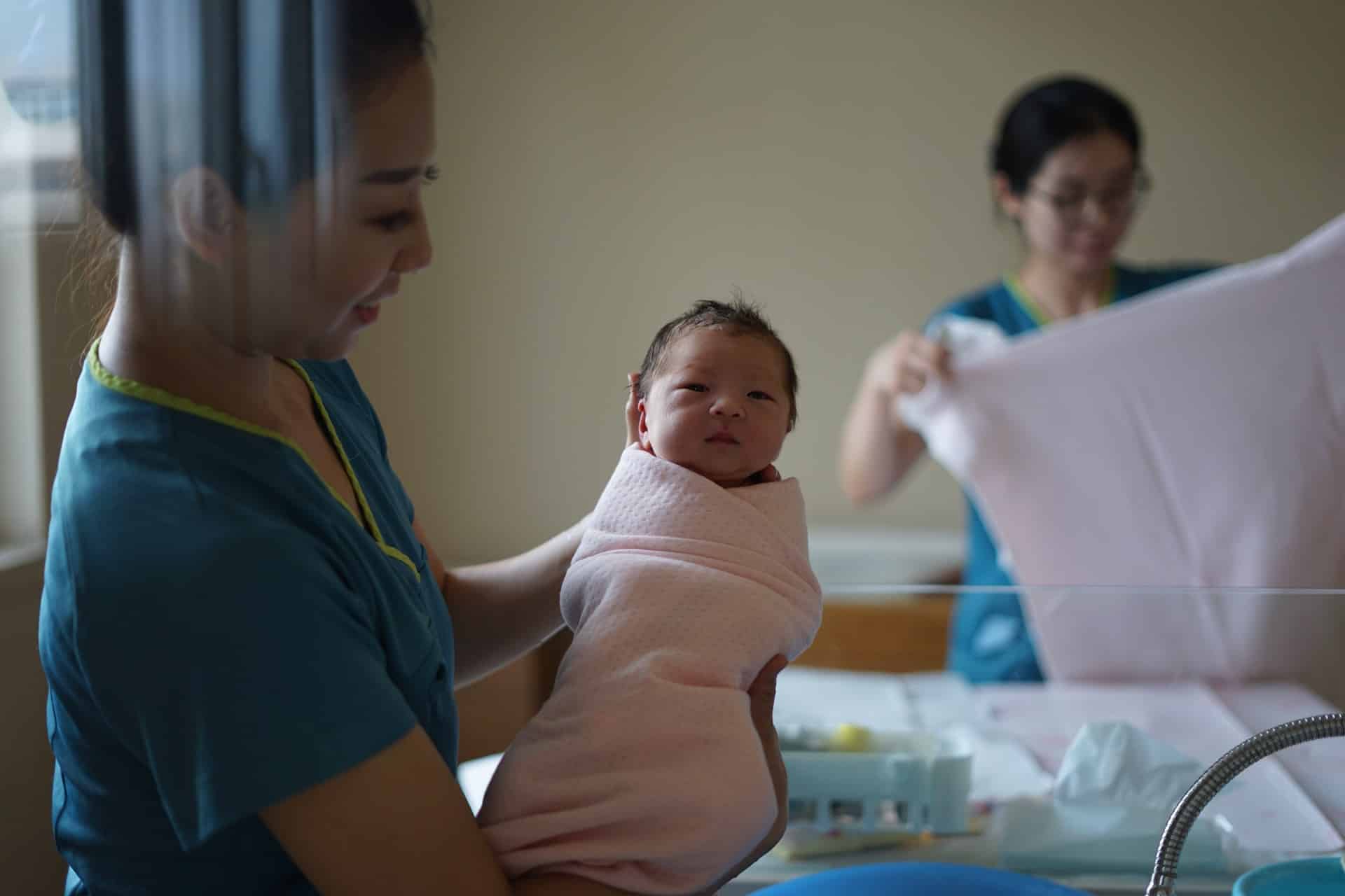 a midwife holding a new born baby