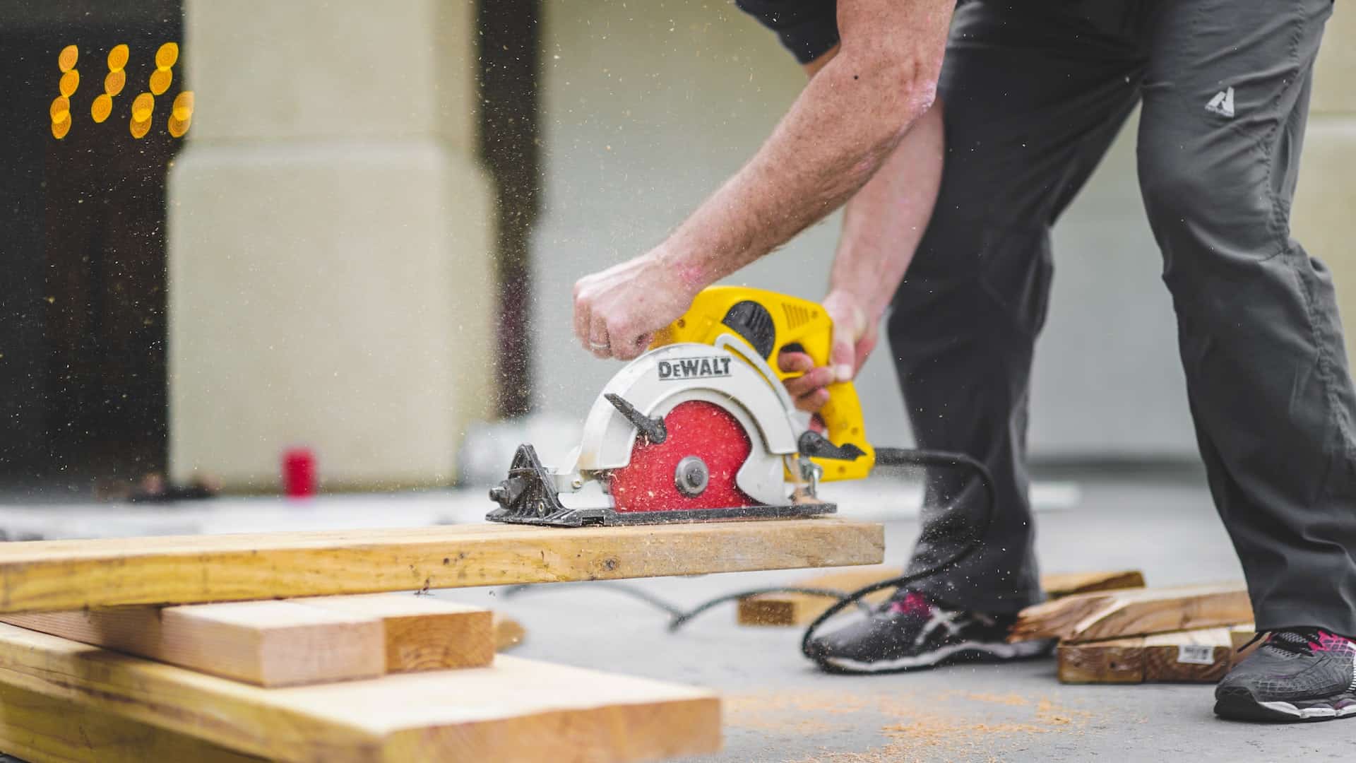 a person sawing wood at construction site