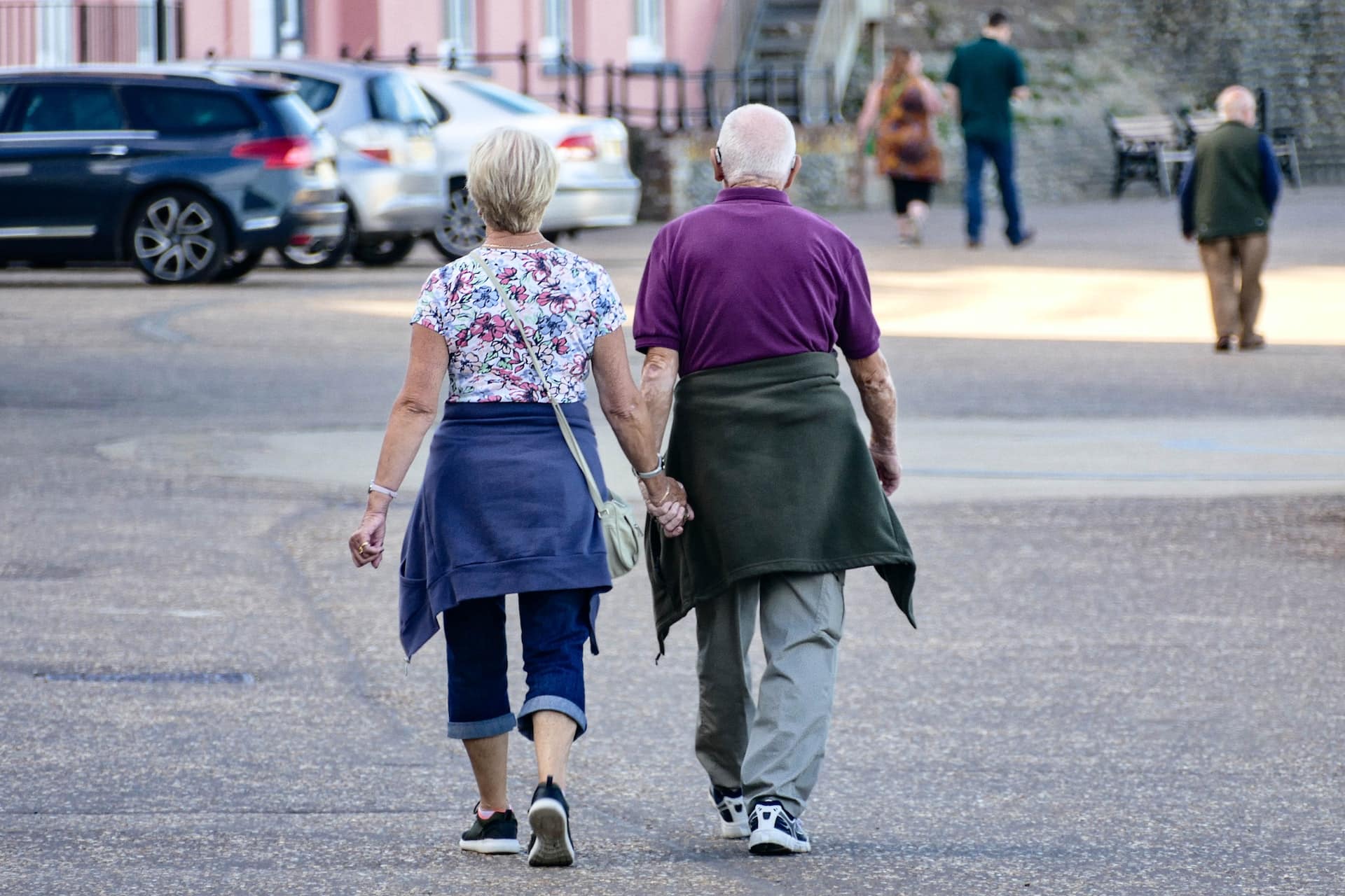 man and woman walking in street holding hands