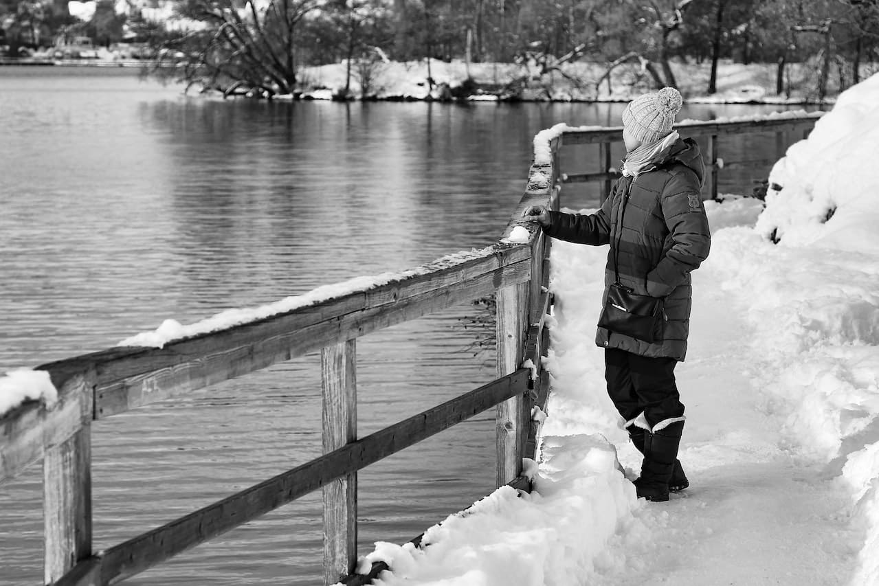 person standing on boardwalk in winter