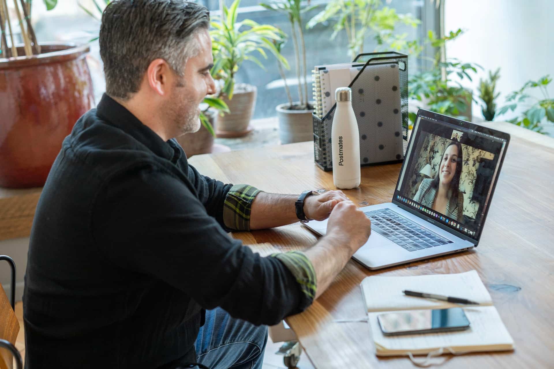 man in sweater using computer for online meeting