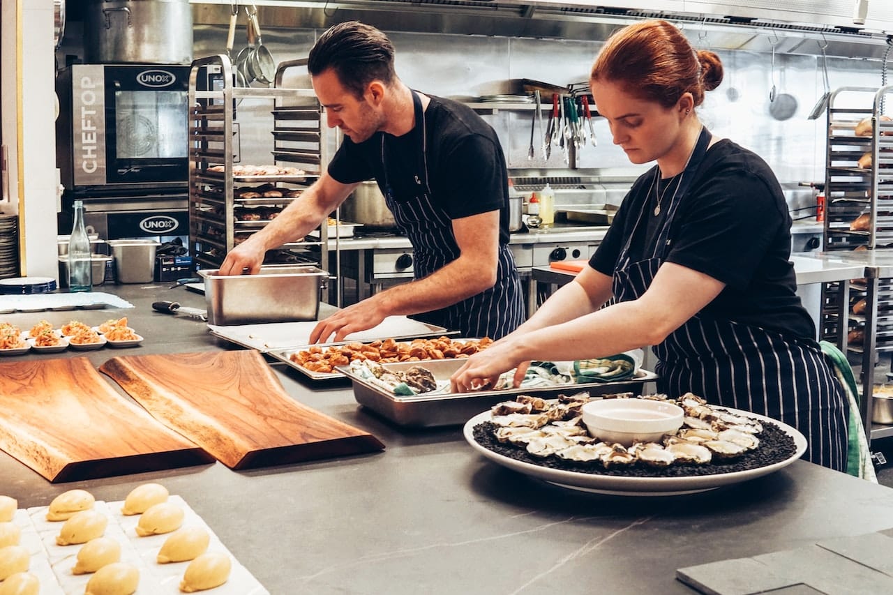 man woman wearing black aprons catering