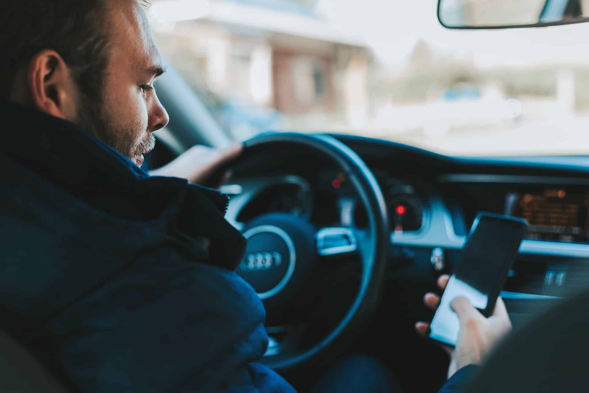 A person looking at cellphone while driving