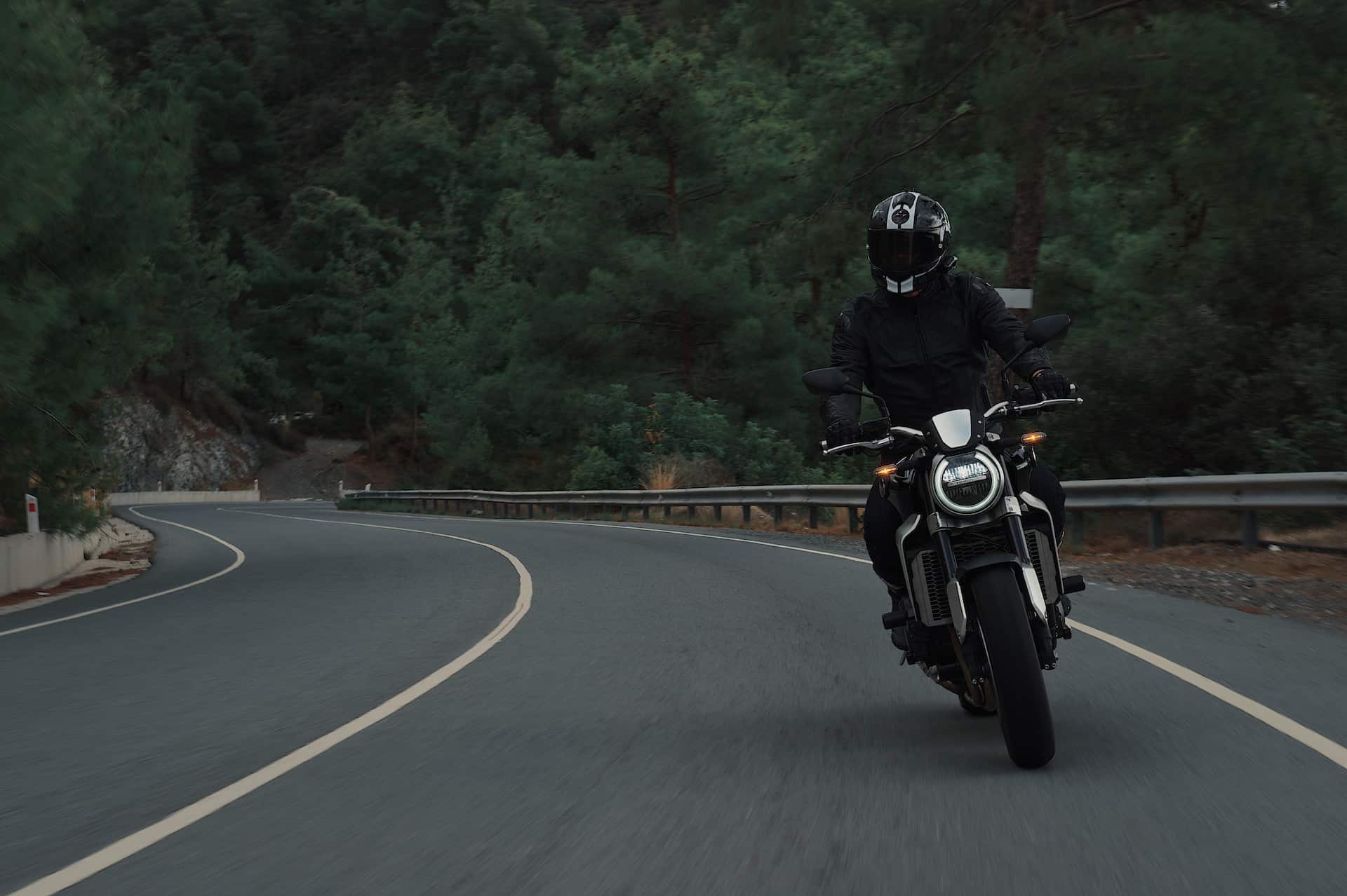 man riding motorcycle on paved road