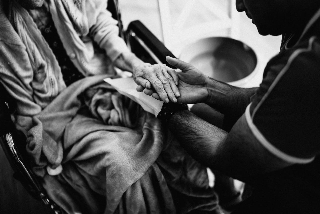 a care worker holding an elderly persons hand