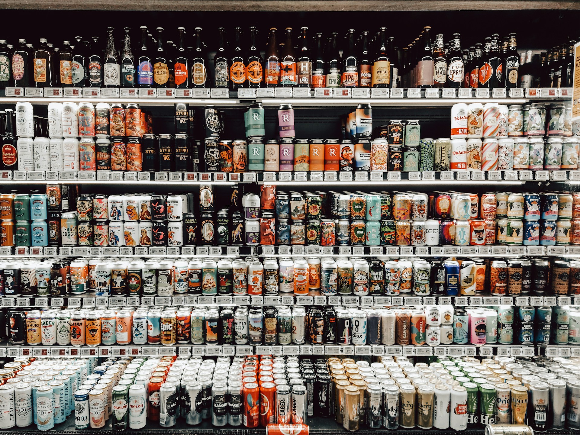 assorted beer in cans on store shelf