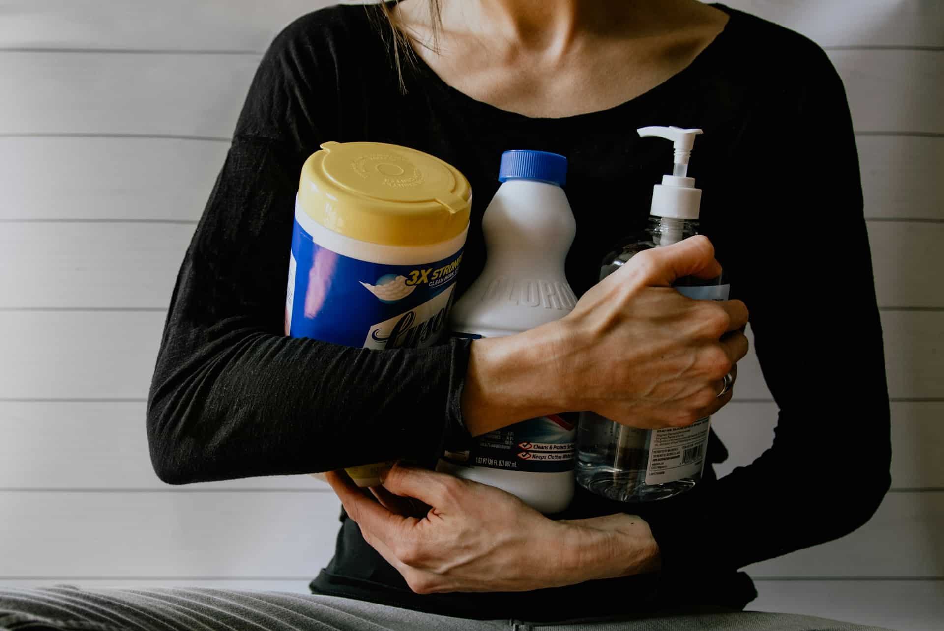 a woman holding cleaning products