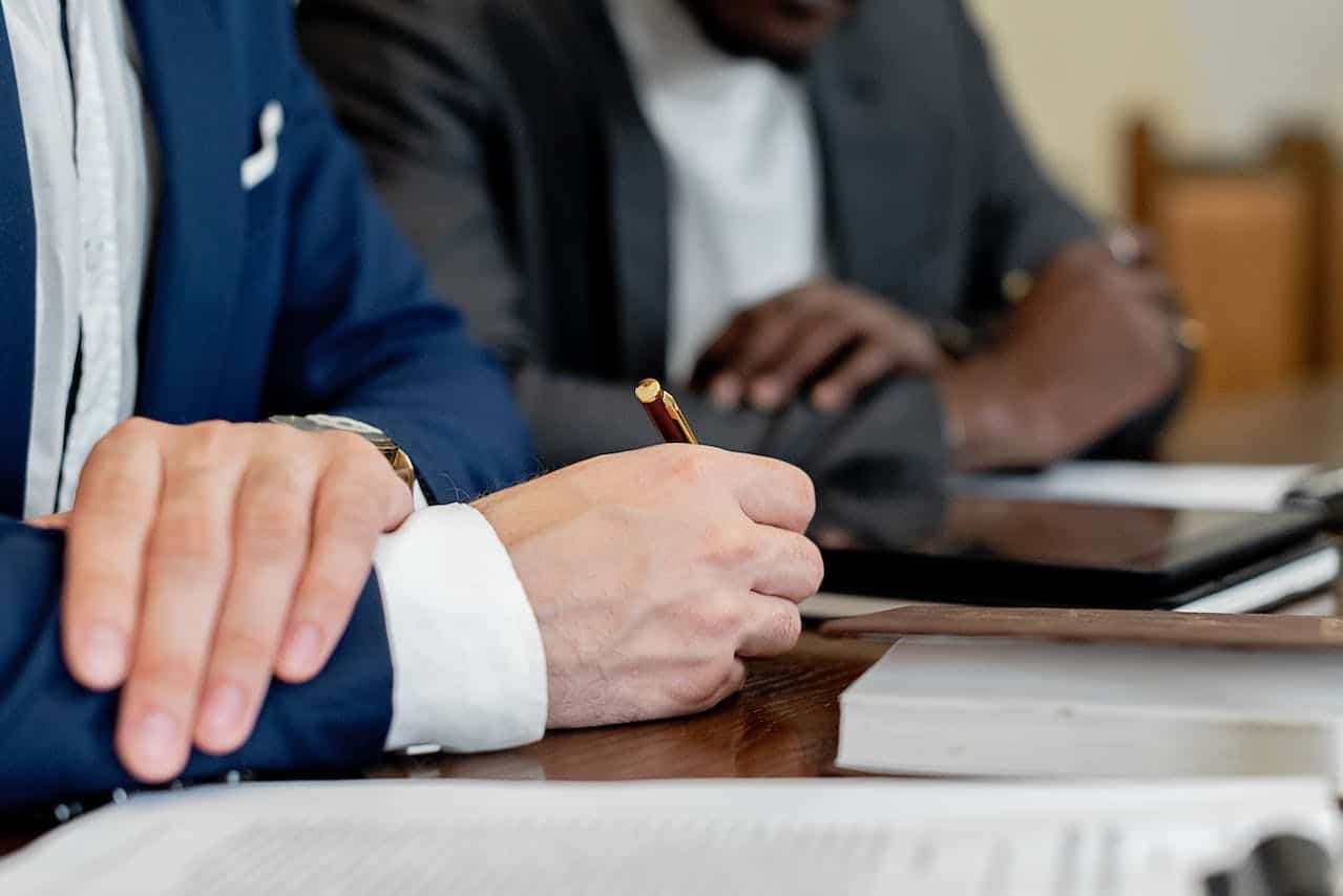 a close up of two people sitting together with paper work