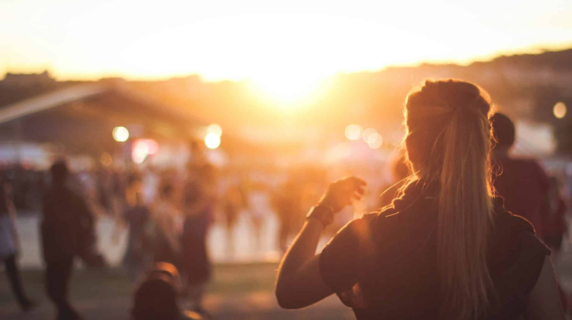silhouette of woman at sunset at an outdoor concert event