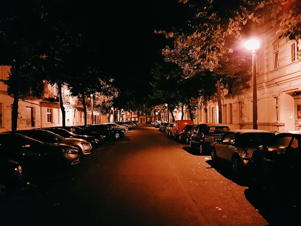 assorted cars parked on side of street at nightime