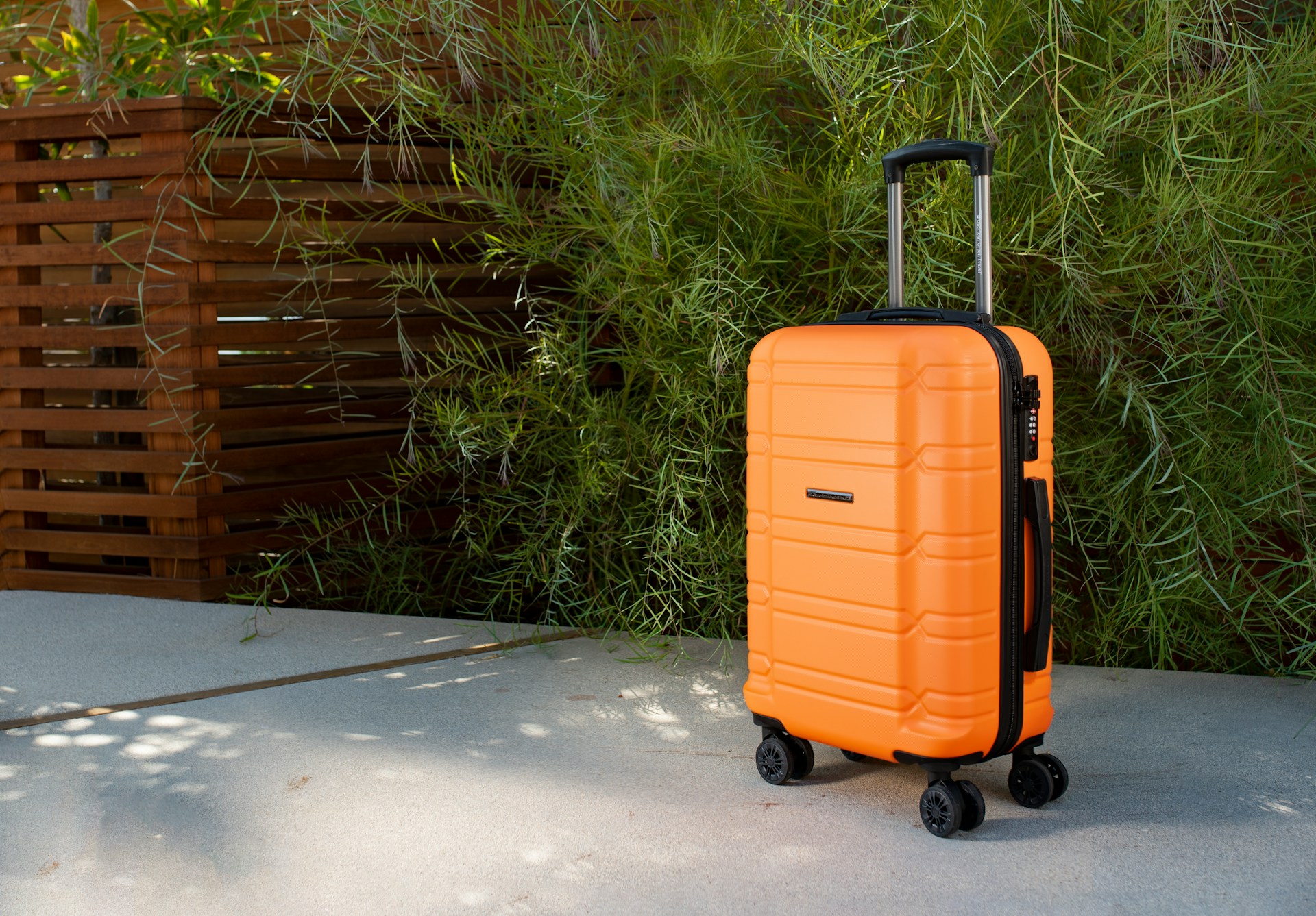 A suitcase on a cement walkway with a bus and a planter behind it, representing short-term rental accidents.
