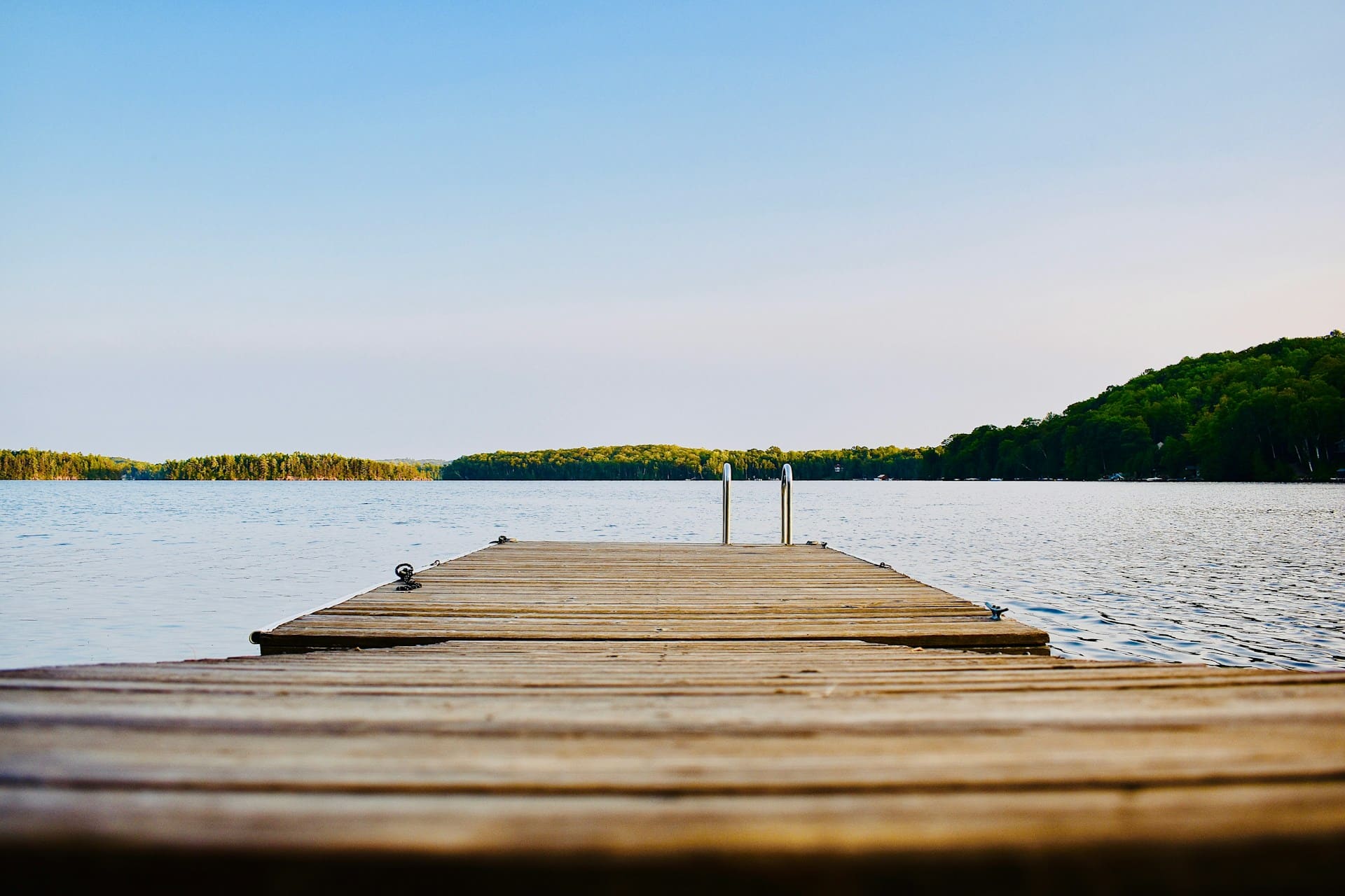 A dock with a swim ladder at the end stretches out into a lake, representing working from the cottage.