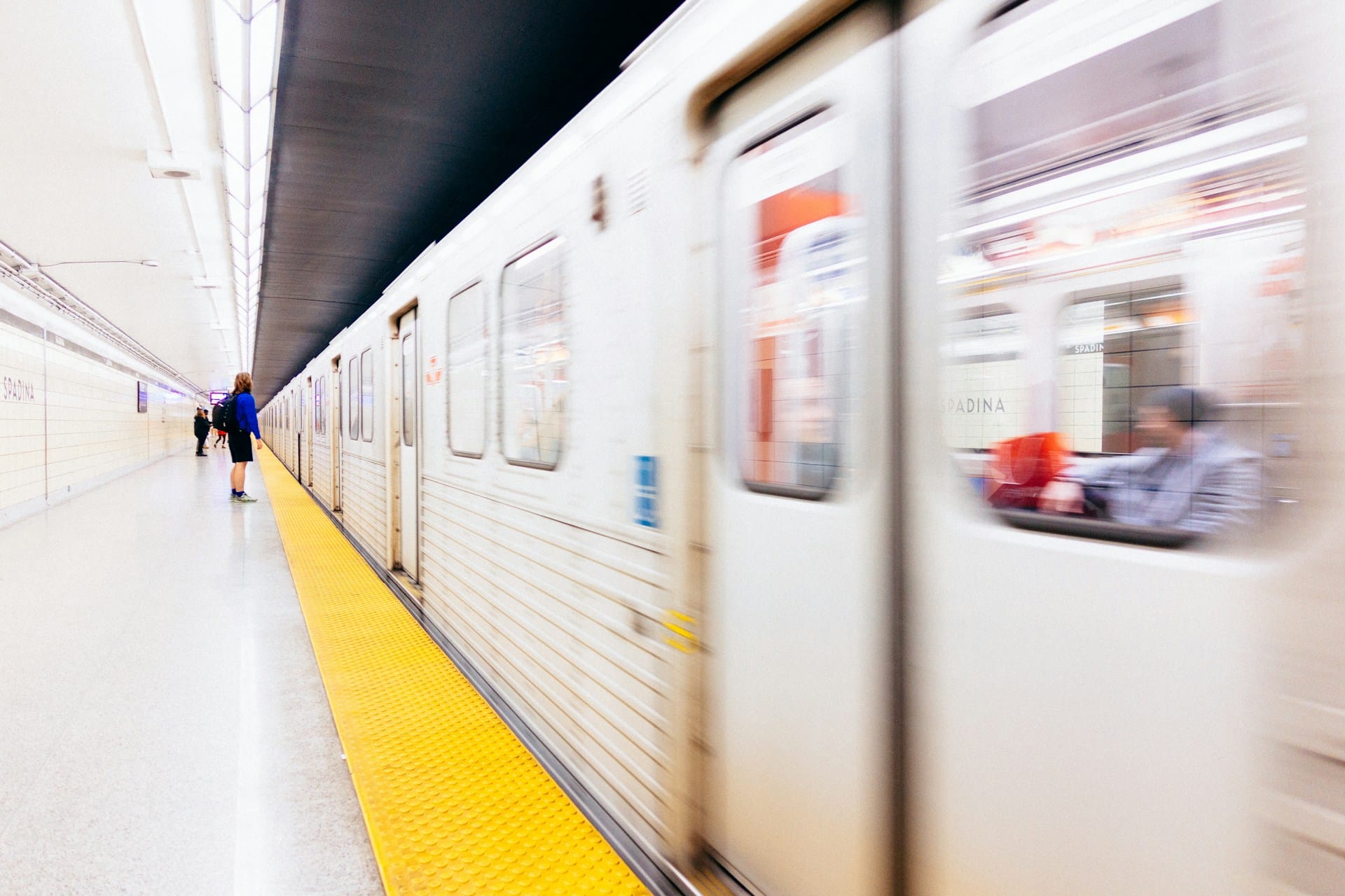 TTC subway pulls into the station where a rider waits behind the yellow line, representing settlement privilege.