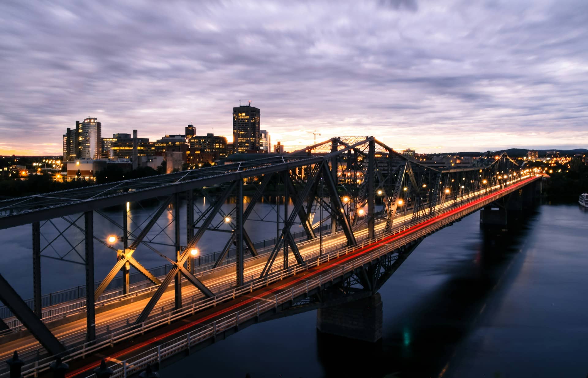 The Alexandra Bridge over the Ottawa River and the Ottawa Skyline in the background at dusk, representing Best Lawyers.