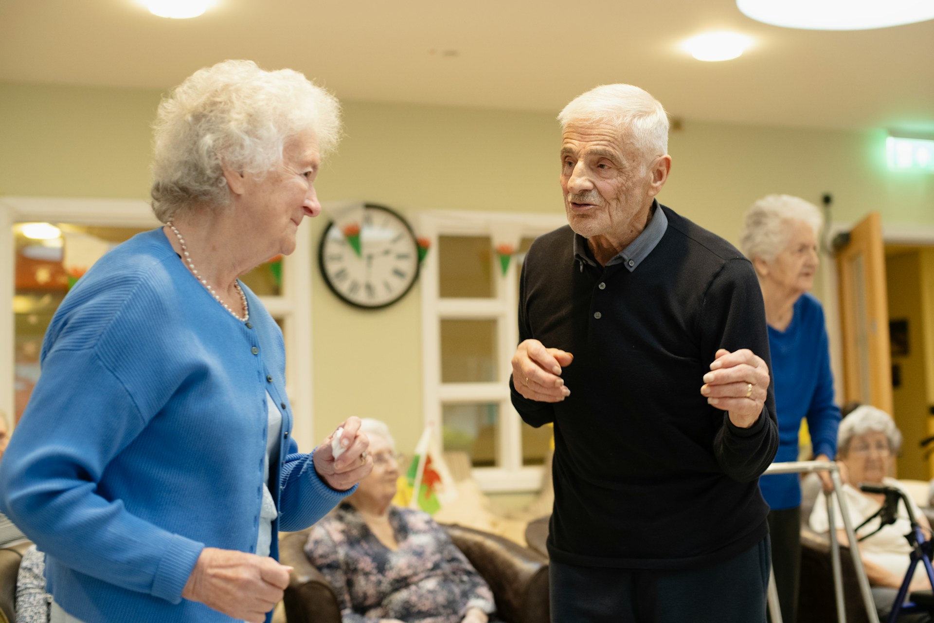 Two elderly people dancing a part in a common area of a retirement home, representing falls from injuries in retirement homes.