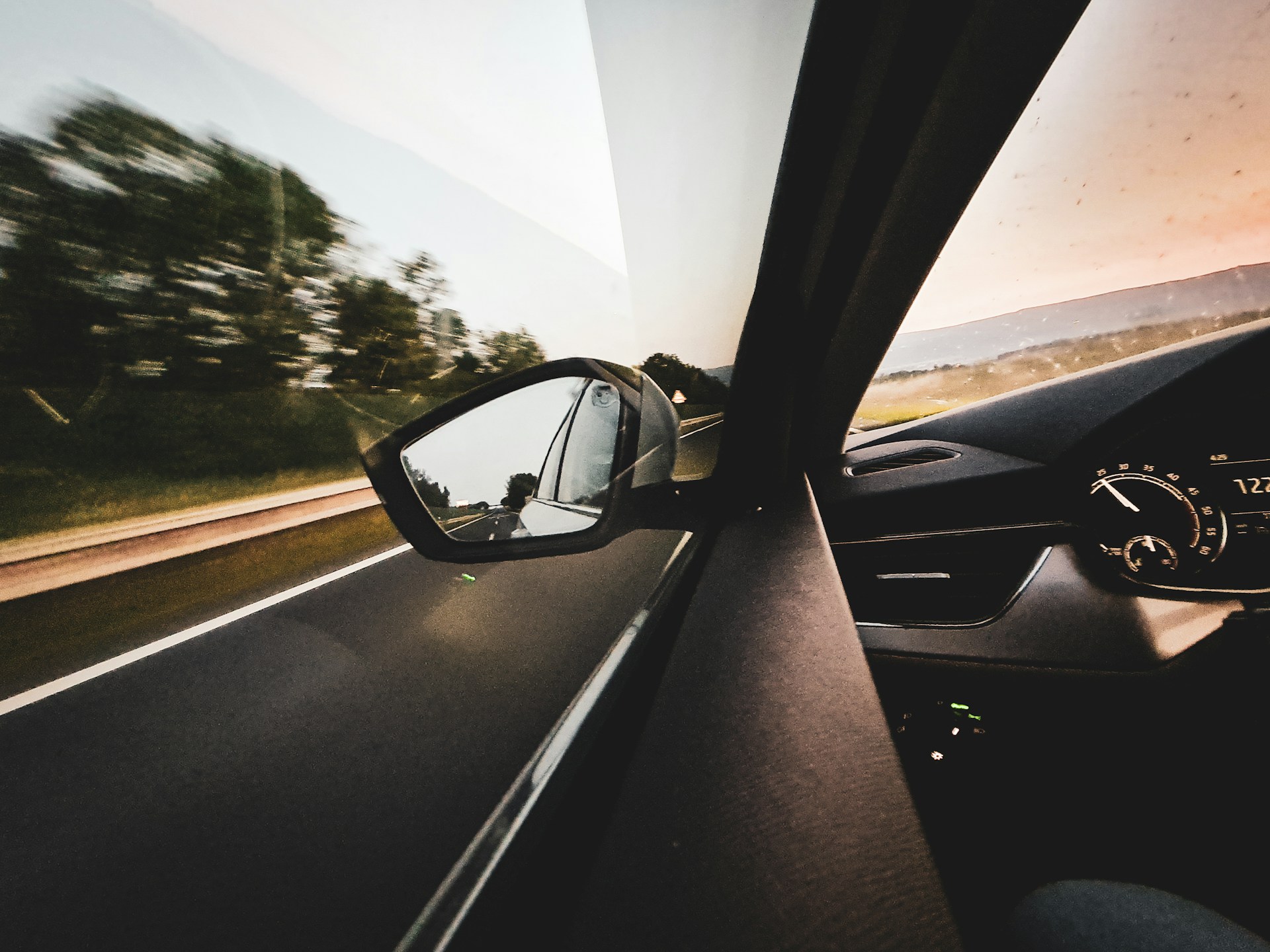 A view of a cars rear view mirror from inside the vehicle, representing Ontario auto insurance
